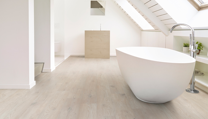 wood look flooring in bathroom with bathtub